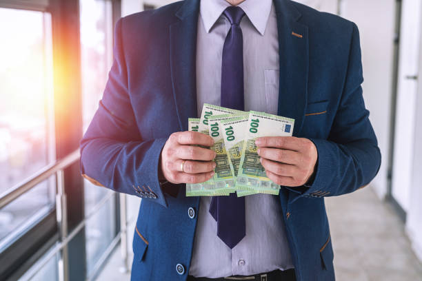 istock Business man in a suit counts euro banknotes 1349943168