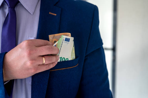 istock Businessman putting euro bills into pocket hit jacket 1349945569