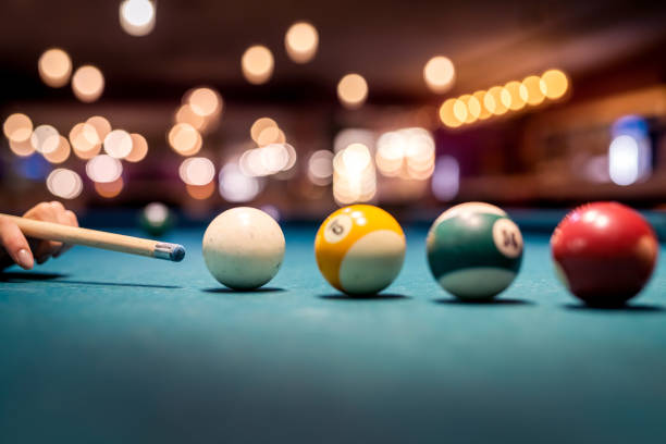 istock female hand preparing aiming the cue ball on a green billiard table 1349945642