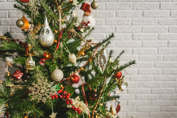 Beautiful decorated Christmas tree on white wall background.