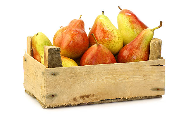 fresh and colorful "Forelle" pears in a wooden crate fresh and colorful "Forelle" pears in a wooden crate on a white background forelle pear stock pictures, royalty-free photos & images