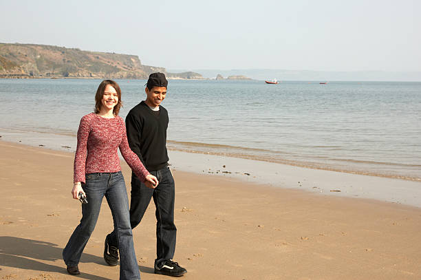 istock Couple walking holding hands on beach 134995257