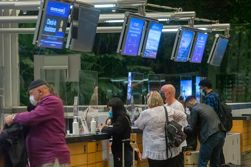 Singapore, Singapore - October 28, 2021: Travellers checking in for a Singapore Airlines flight at the departure hall of Terminal 3, Changi Airport.