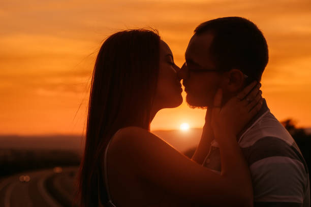 istock Couple silhouette kissing at sunset 1349954940