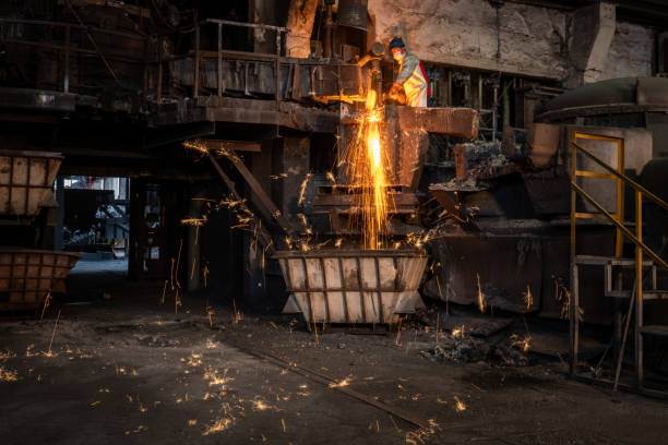 istock Metal worker discharging molten metal into container in foundry 1349955608