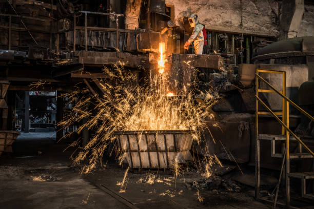 istock Metal worker discharging molten metal into container in foundry 1349955635