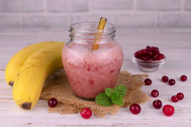 cranberry und bananen-smoothie in einem glas auf weißem hintergrund. - healthy lifestyle cranberry healthy eating milk shake stock-fotos und bilder