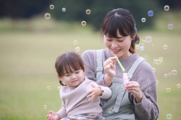 Parents and children playing with soap bubbles