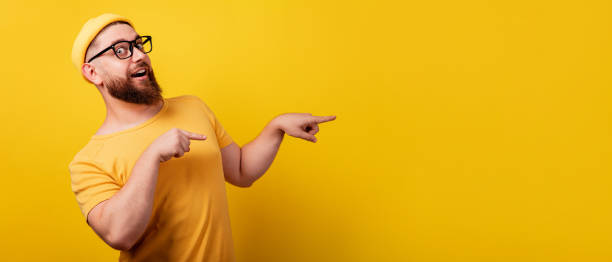 istock smiling bearded man in glasses point index finger 1349960405