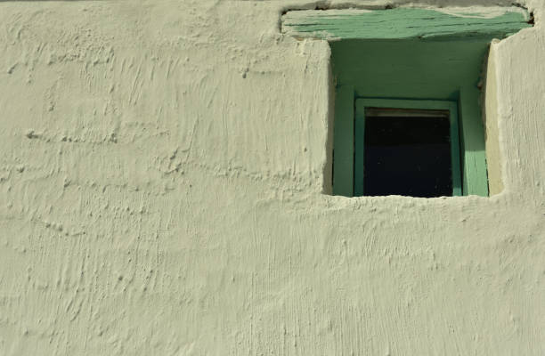 istock A small old-fashioned window with green wooden frame in a whitewashed wall 1349960520