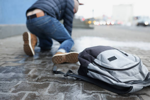 istock Backpack lying on slippery paving slabs near falling man closeup 1349963508