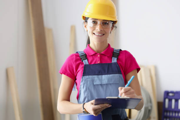 istock Woman builder in protective helmet holding clipboard with documents 1349965894