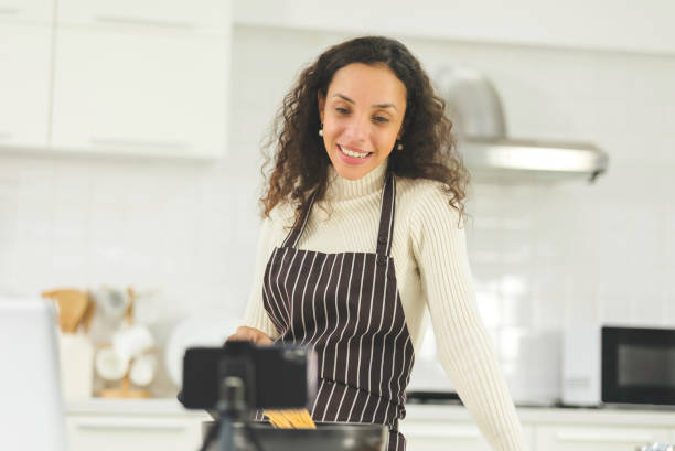 Blogger black women are beginning a home-based business to online teach cooking. Smartphone live streaming in social media. Work from home. Blogger black women are beginning a home-based business to online teach cooking. Smartphone live streaming in social media. Work from home. image based social media photos stock pictures, royalty-free photos & images