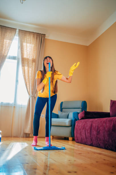 istock Woman singing while cleaning house 1349972536