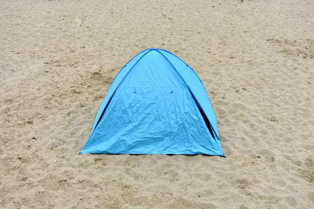 istock close up of isolated domed, triangular shaped blue tent on sand at a beach 1349972700