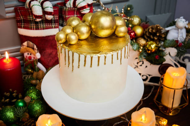 istock Christmas cake with vanilla biscuit, curd cream and strawberries decorated with chocolate christmas balls on the background of candles, garlands, fir branches and cones 1349972890