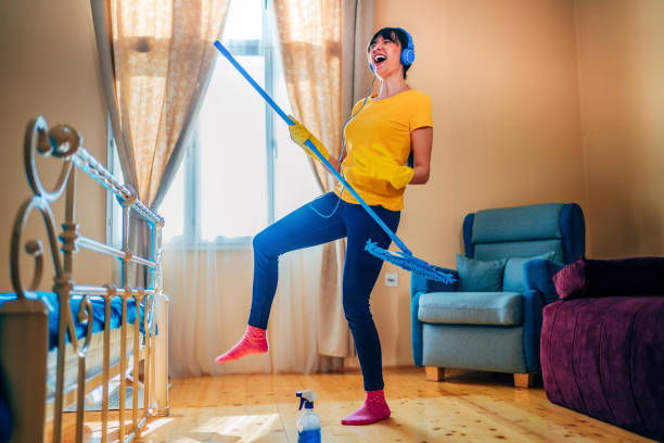 istock Woman having fun while cleaning house 1349972938