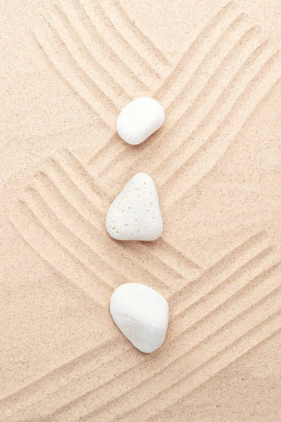 istock White stones on the sand. Lines drawn on the sand. Top view 1349973685