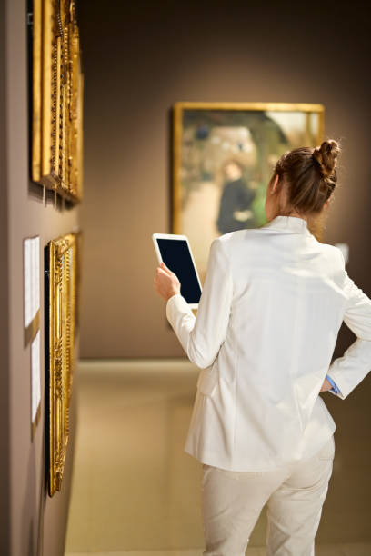 donna visitatrice nel museo storico guardando le immagini - ancient old traditional culture inside of foto e immagini stock