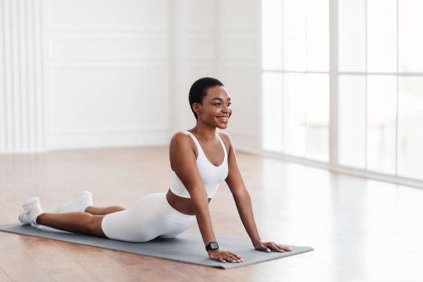 istock Young black woman stretching back on mat in cobra pose 1349979063