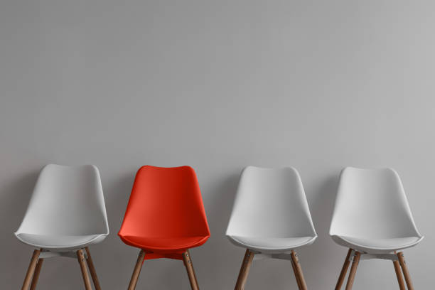 istock Three white chairs and red on gray wall background in office or room 1349979789