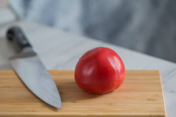 istock tomato and knife on a cutting board 1349980329