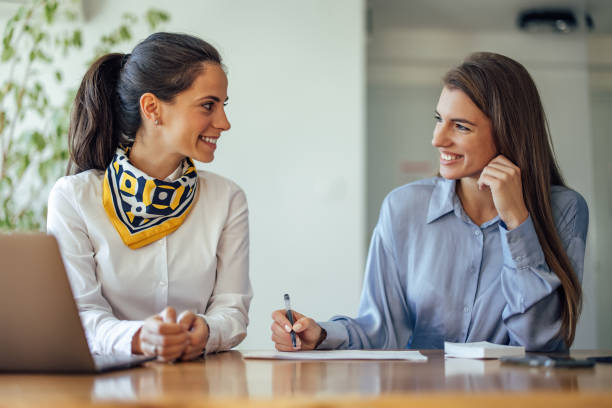 istock Two friends, signing work papers, at the office 1349987030