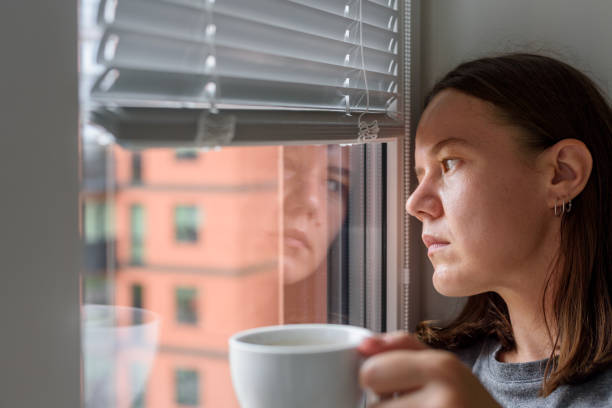 istock Anxious woman looking to window 1349989935