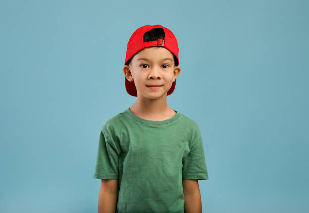 retrato de menino asiático bonito de chapéu vermelho e camiseta verde - child little boys isolated standing - fotografias e filmes do acervo