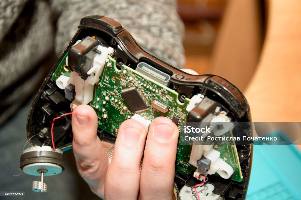 Repair of the PlayStation game joystick in the service center Repair joystick service center,  Board, computer, electronics, equipment repair, computer board, repair, service center, it, game console, joystick, game console, PlayStation, virtual games Brand Name Video Game Stock Photo