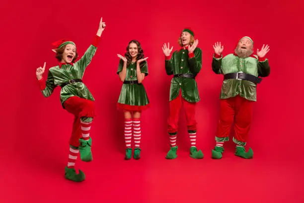 Full body photo of astonished santa family yell wear new year costumes isolated on red color background.