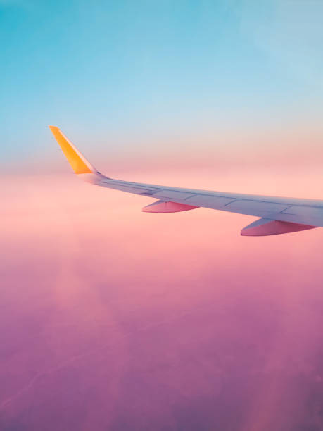 vista viola surreale dal finestrino di un aereo, fantastico volo di vacanza da sogno, concetto - wing airplane window sunset foto e immagini stock