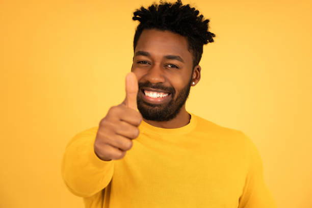 istock Afro man smiling while showing thumbs up to camera. 1350004418