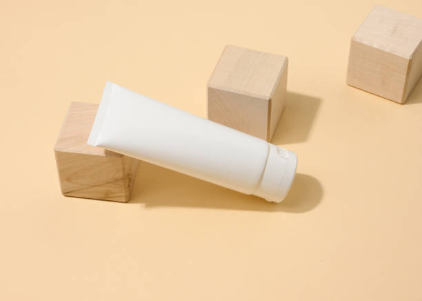 istock empty white plastic tubes for cosmetics on a white table. Packaging for cream, gel, serum, advertising and product promotion 1350004760