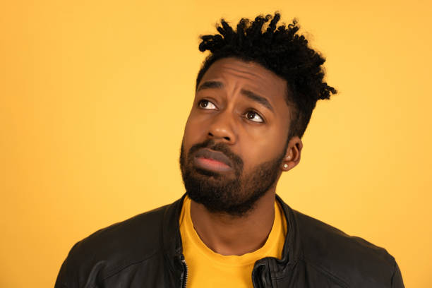 istock Afro man thinking and wondering about something while standing on an isolated background. 1350005176