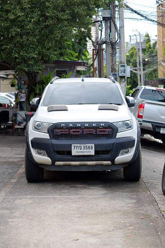 Front of white colored Ford Ranger Pick-up  parked between other cars in Bangkok