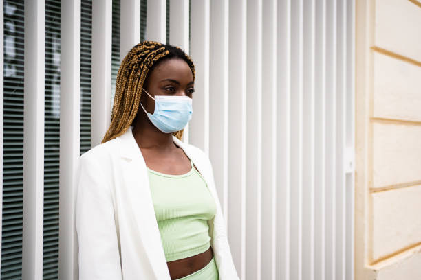 istock Profile of an afican young woman using mask while standing outside 1350010504