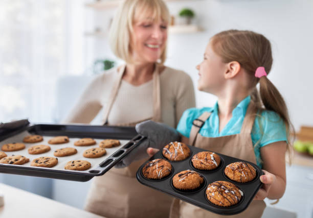 szczęśliwa starsza babcia i jej wnuczka pokazujące ciasteczka - grandmother pie cooking baking zdjęcia i obrazy z banku zdjęć