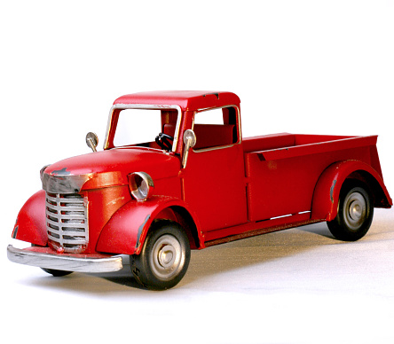 Vintage Red Tin Toy Decorative Christmas Truck at 3 quarter angle against white background