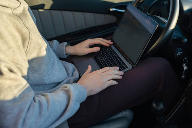 istock young man with laptop in car 1350011757