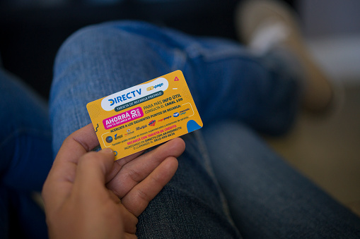 Detail of woman sitting on a sofa using a DIECTV prepaid card