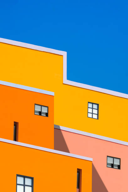 manipulationstechniken für architektonische merkmale hintergrundgestaltung von bunten gebäuden vor blauem klarem himmel - building feature fotos stock-fotos und bilder