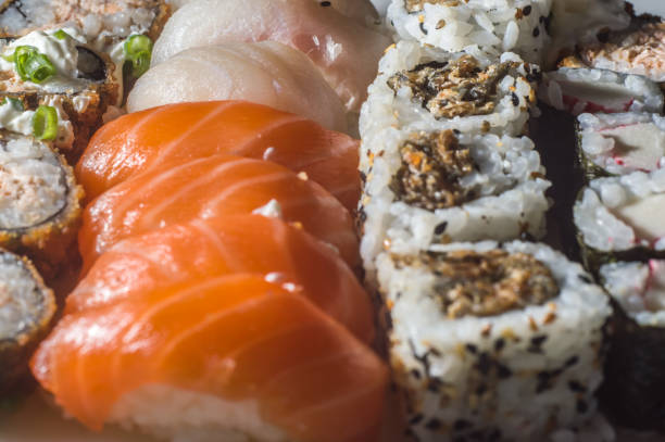 textura de sushi con diferentes tipos de sushi entre ellos: kani, niguiri, uramak - niguiri sushi fotografías e imágenes de stock