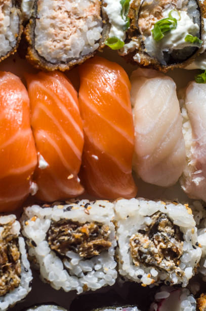 textura de sushi con diferentes tipos de sushi entre ellos: kani, niguiri, uramak - niguiri sushi fotografías e imágenes de stock