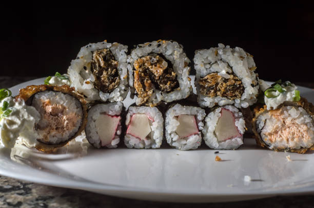 istock sushi, several types of sushi on a white plate and black background 1350013059