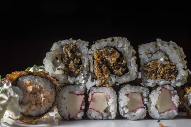 istock sushi, several types of sushi on a white plate and black background 1350013141