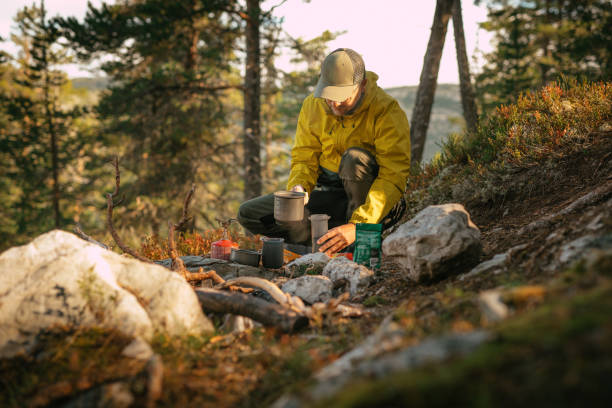 istock Camping in the North. Man preparing tea in the wild 1350013434