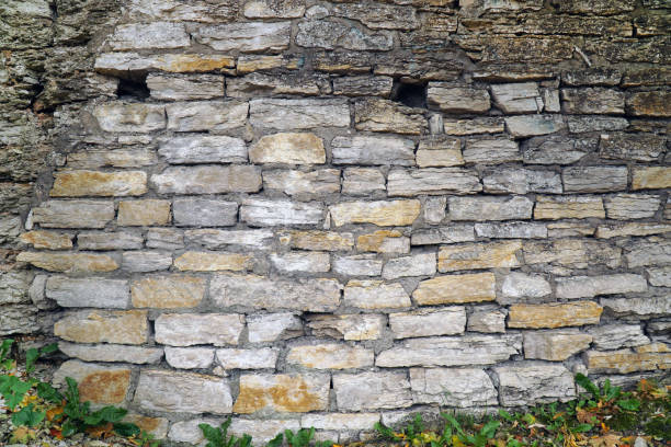 istock old stone wall of yellow brick with holes 1350013467
