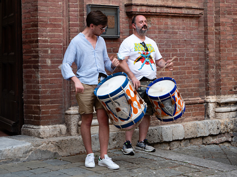 Siena, Tuscany, Italy - August 15 2021: Drummers of the Contrada del Leocorno or Unicorn Contrade at the Chiesa di San Giovannino della Staffa Church Entrance