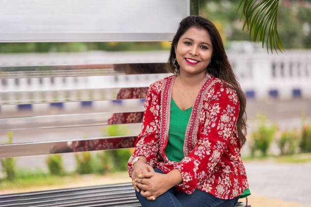 istock Young happy woman sitting on bench in park 1350013885